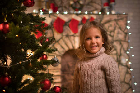 Baby girl in christmas interior with fireplaceの写真素材