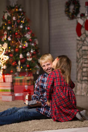 brother and sister near the Christmas tree on Christmas nightの写真素材