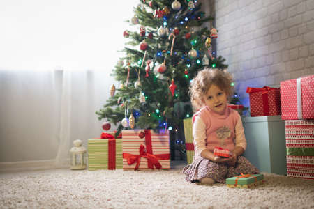 Girl sitting near the Christmas treeの写真素材