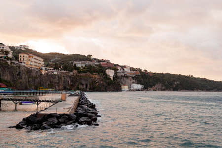 SORRENTO, ITALY NOVEMBER 4 2019: Pink sunset at Sorrento city view with houses, fortress and sea shore from the pierのeditorial素材