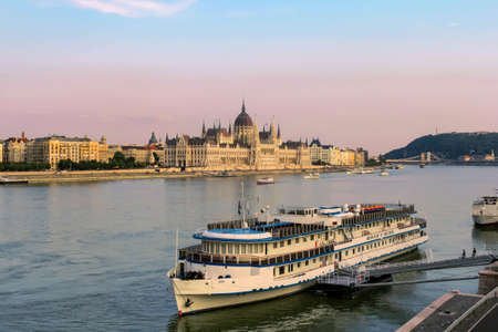 BUDAPEST, HUNGARY JULY 29, 2019: Beautiful evening view on Hungarian Parliament Building along Danube River with cruise ships on natural background. Text copy space.のeditorial素材