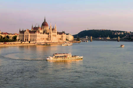 BUDAPEST, HUNGARY JULY 29, 2019: Beautiful evening view on Hungarian Parliament Building along Danube River with cruise ships on natural background. Text copy space.のeditorial素材
