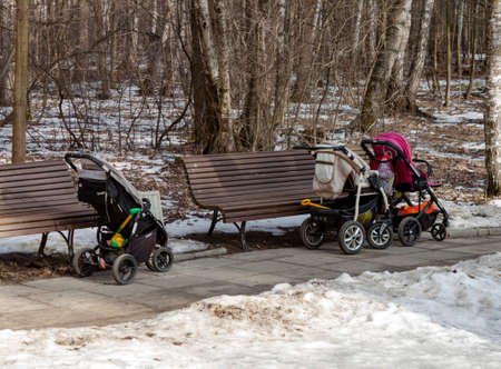 Moscow, Russia 22 February 2020: Strollers near benches at childrens playground on spring park natural background. Childhood, maternity concept. Selective soft focus. Text copy spaceのeditorial素材
