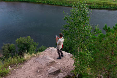Kungur, Perm region, Russia - August, 8 2020: unrecognized person making photos of Chusovaya river...