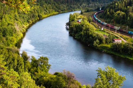 Kungur, Perm region, Russia - August, 8 2020: long multicolored freight train view from Ermak stone