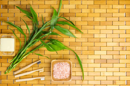 Spa, zen, massage concept. Bath salt, bamboo leaves, soap dish, toothbrush. Top view. Flat lay.の写真素材