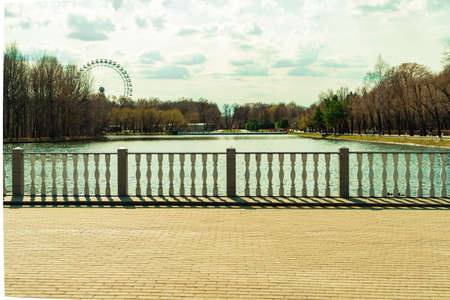 Moscow, Russia April 18 2021: Izmailovsky park pond stone balustrade and view on ferris wheelのeditorial素材