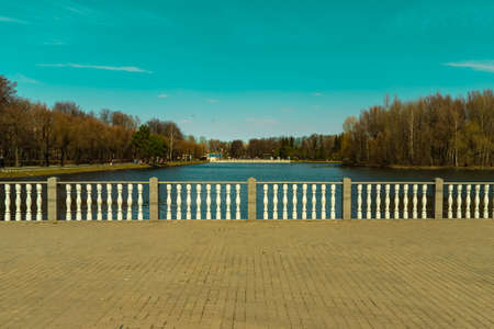 Moscow, Russia April 18 2021: Izmailovsky park pond stone balustrade with white columns springtime sunny day card. Text copy space.の写真素材