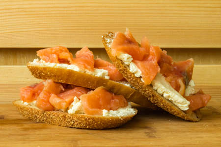 Salted salmon and ricotta cheese homemade sandwiches on wooden table. Healthy breakfast concept.の写真素材