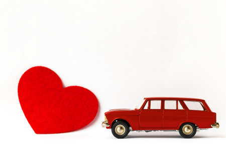 Red metal retro toy car and heart on white background. Valentines day conceptの写真素材