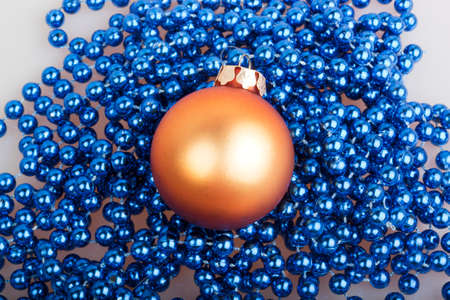 Orange Christmas ball and blue beads on a white backgroundの写真素材