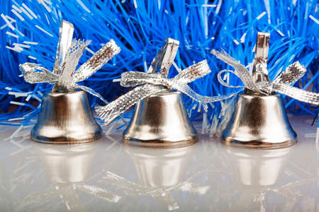 three silver bells on the background of blue garlandの写真素材