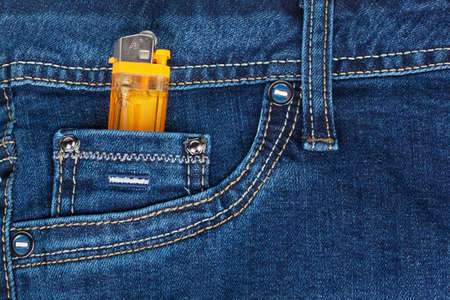 orange lighter in dark blue jeans pocketの写真素材