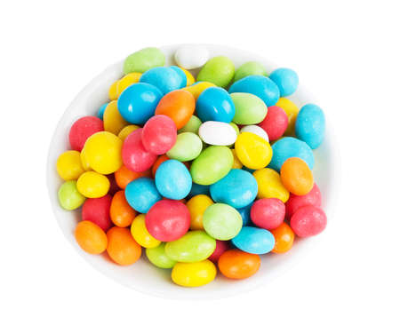 colored candies in white saucer isolated on white background