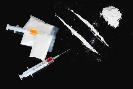 Cocaine and syringes on black backgroundの写真素材