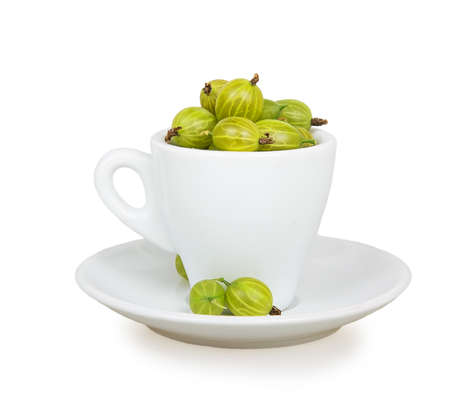 Gooseberries in white cup and saucer isolated on white backgroundの写真素材