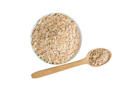 Plate and a large wooden spoon with porridge isolated on white background