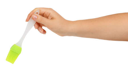 Silicone pastry brush in female hand isolated on white backgroundの写真素材