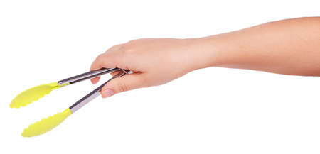 Cooking tongs in female hand isolated on a white backgroundの写真素材