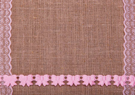 Background of burlap with pink laces on the edgesの写真素材