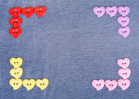 Multi-colored buttons in the shape of hearts on jeans backgroundの写真素材