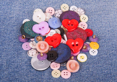 Sewing color buttons on denim jeans backgroundの写真素材