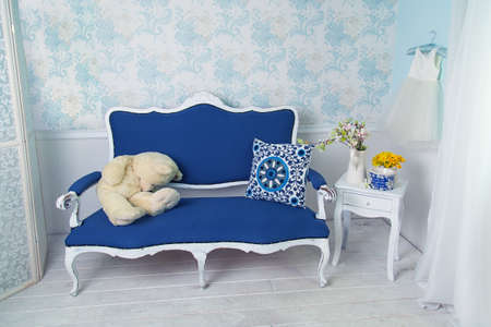 Blue classical style sofa couch with white teddy bear in vintage roomの写真素材