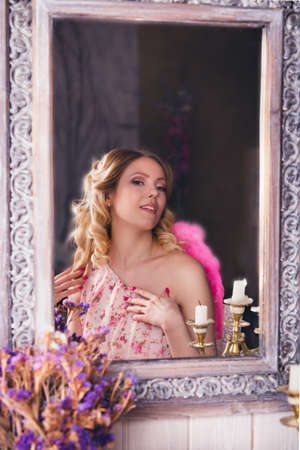 Young beautiful woman in angel costume in the mirrorの写真素材