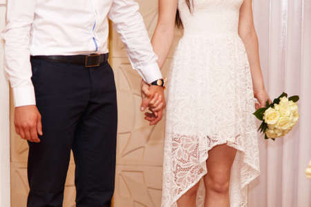 Bride and groom holding hands in a registry officeの写真素材