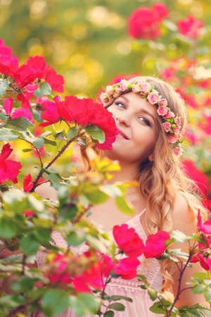 Beautiful pregnant woman relaxing outside with red roseの写真素材