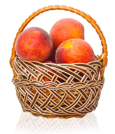 Ripe peaches in a wicker basket isolated on white backgroundの写真素材