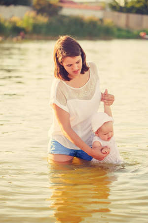 Mother and daughter are in the river in summerの写真素材