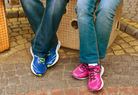 Close up of male and female's feet with shoes relaxing after a walkの写真素材