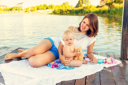 Mother and baby are resting on the river bankの写真素材