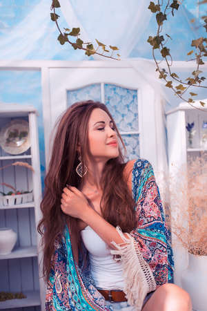 Beautiful sexy woman has a rest in an open arbor on a tableの写真素材