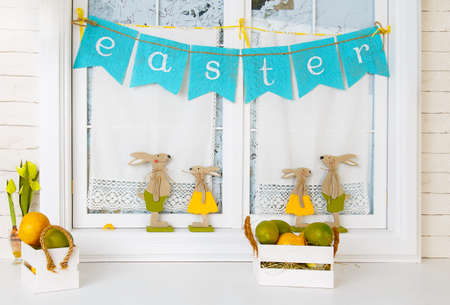 Easter bunnies and eggs on the windowの写真素材