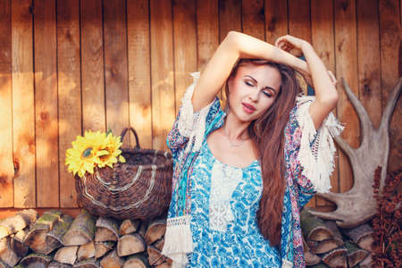 portrait of a beautiful sexy woman standing and posing outdoors on the background of wood  in the gardenの写真素材