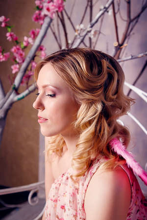 Portrait of young beautiful woman in angel costume with pink wings in studio