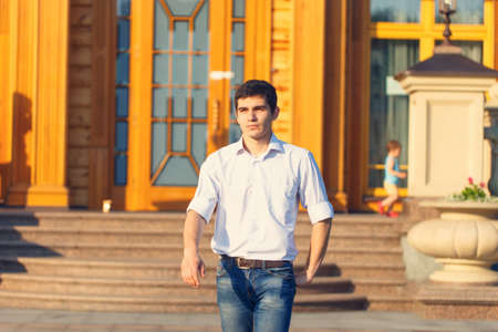 Young handsome man walking along the streetの写真素材
