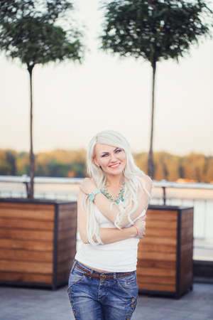 cheerful young woman loves hugging herself outdoorの写真素材