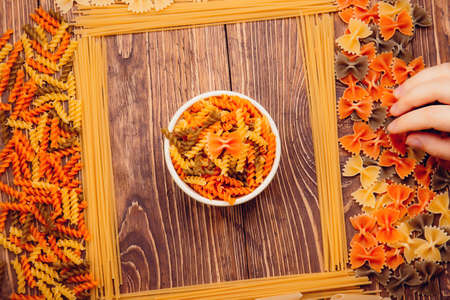 frame of spaghetti and pasta on retro wooden background. In the middle of a bowl.の写真素材