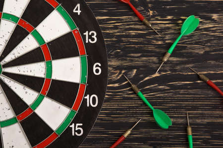 The darts isolated on dark wooden background