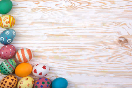 Colored Easter eggs on light wooden background
