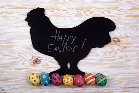 vintage easter decoration with eggs on light wooden background. chalkboard with sample text Happy Easterの写真素材