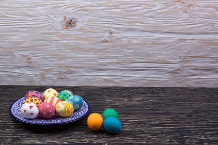 plate with Easter eggs on dark wooden backgroundの写真素材
