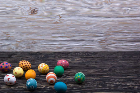 Painted Easter eggs on dark wooden background.の写真素材