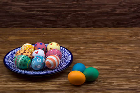 plate with Easter eggs on dark wooden backgroundの写真素材