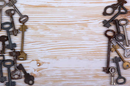 A lot of old keys on light wooden backgroundの写真素材