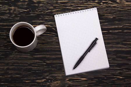 notebook with pen and mug  on old  wooden tableの写真素材