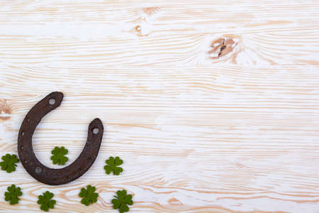 Fabric green clover leaves with horseshoe on light wooden background.の写真素材